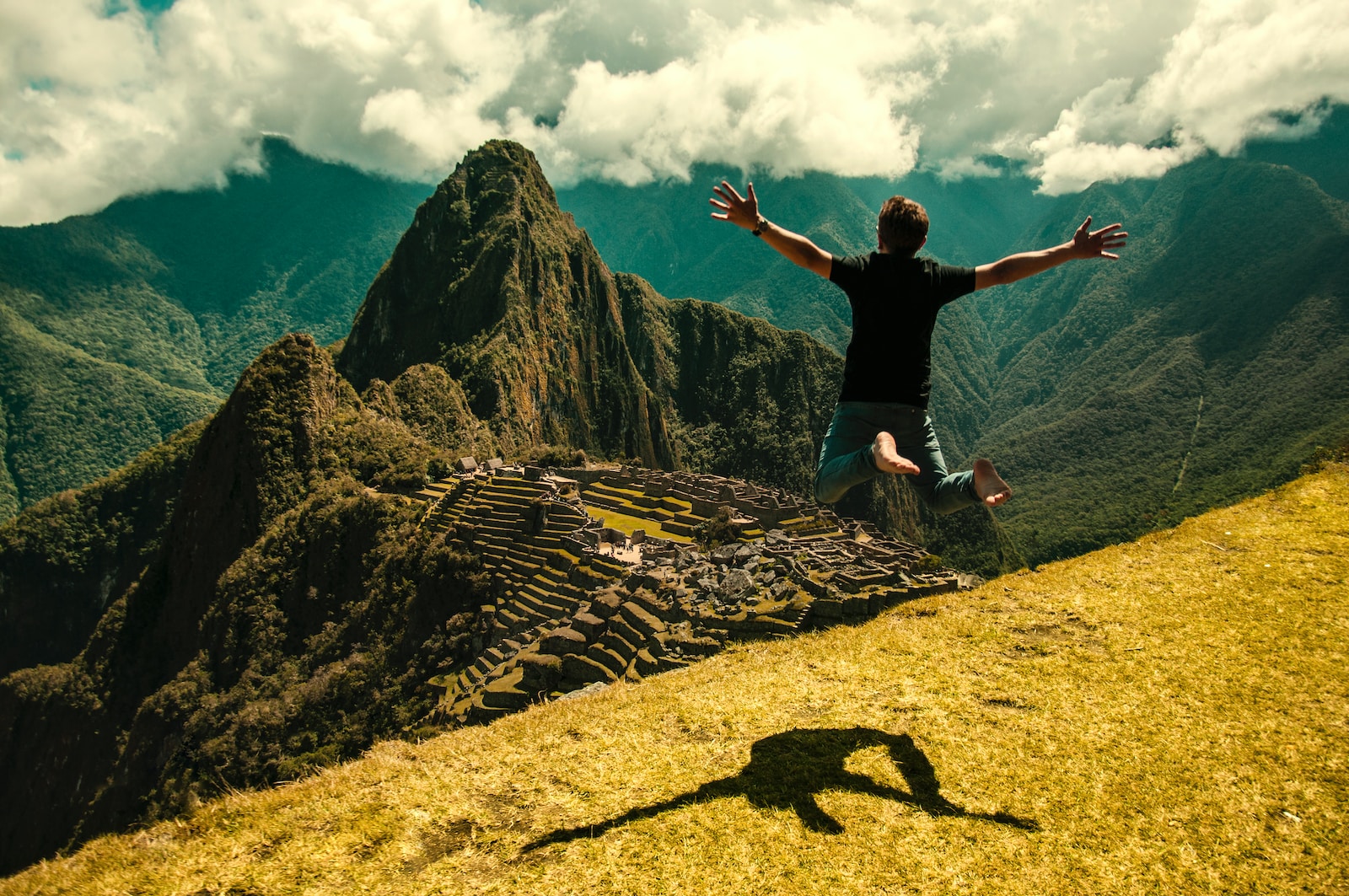 man jumping in green open field Machu Picchu rese äventyr berg natur